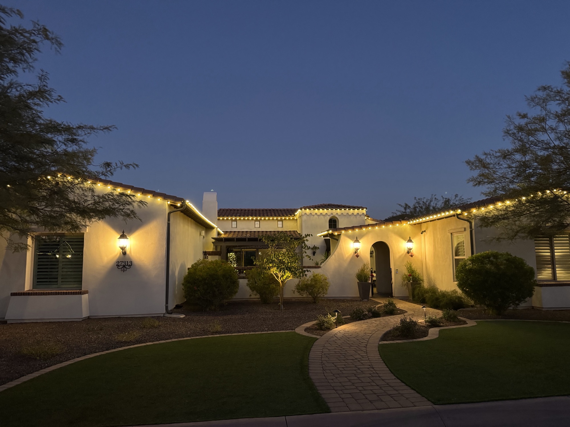 Roofline lighting and paver walkway at a Scottsdale home at dusk